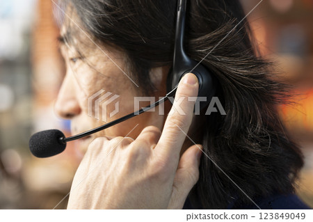 Call center staff member using headphones mic to answer technical inquiries about hardware issues. Knowledgeable Asian worker doing customer support job using PC to troubleshoot problems, close up Call center staff member using headphones mic to answer technical inquiries about hardware issues. Knowledgeable Asian worker doing customer support job using PC to troubleshoot problems, close up 123849049