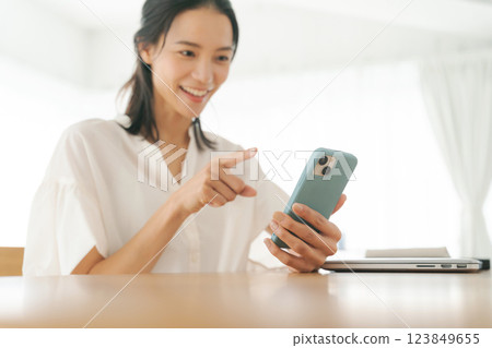 一名 30 多歲的女性,擁有智慧型手機 一名 30 多歲的女性,擁有智慧型手機 123849655