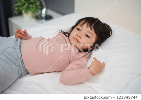 toddler girl lying on bed 123849744