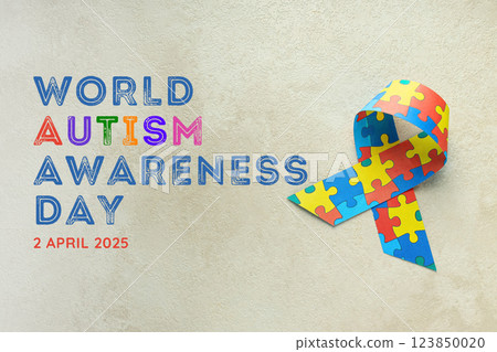 Autism Day, ribbon with colorful puzzles on a light background, with text, top view 123850020