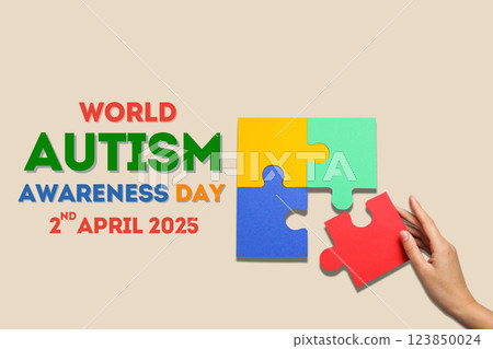 Autism Day, puzzle piece, hand and text on a beige background 123850024