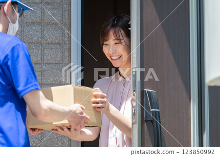 Female delivery person who receives the parcel Female delivery person who receives the parcel 123850992