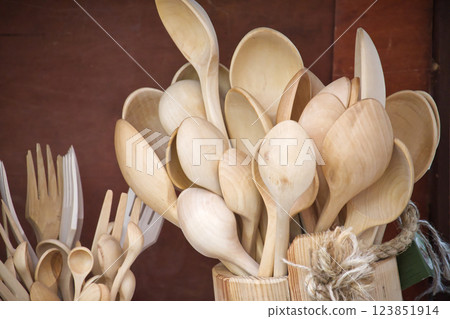 Collection of handcrafted wooden kitchen utensils, including spoons and forks, displayed together. 123851914
