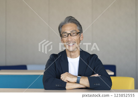 A man in his 60s smiling and talking to the camera A man in his 60s smiling and talking to the camera 123852555
