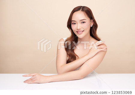 A beautiful young Asian woman with clean, fresh skin against a beige background. She represents beauty, skincare, and spa treatments. A beautiful young Asian woman with clean, fresh skin against a beige background. She represents beauty, skincare, and spa treatments. 123853069
