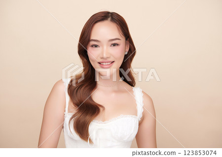 A beautiful young Asian woman with clean, fresh skin against a beige background. She represents beauty, skincare, and spa treatments. A beautiful young Asian woman with clean, fresh skin against a beige background. She represents beauty, skincare, and spa treatments. 123853074