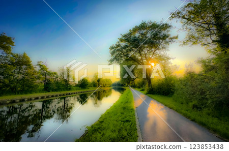 The Serene River Pathway at Sunrise offers a stunning and peaceful view, ideal for exploration 123853438