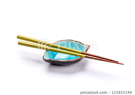 A sushi chopsticks and a small bowls, elegantly arranged on a clean white background A sushi chopsticks and a small bowls, elegantly arranged on a clean white background 123855249