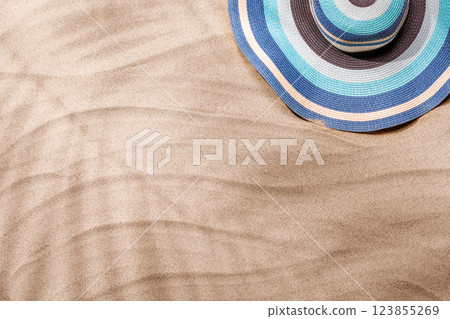 A tropical summer background featuring soft beach sand with delicate palm leaf shadows and sunhat A tropical summer background featuring soft beach sand with delicate palm leaf shadows and sunhat 123855269