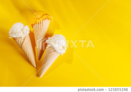 A refreshing ice cream cones set against a vibrant yellow background 123855298