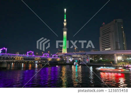 夜晚駛過燈火通明的隅田川大橋的屋形船和綠色的天空樹夜景 夜晚駛過燈火通明的隅田川大橋的屋形船和綠色的天空樹夜景 123855458