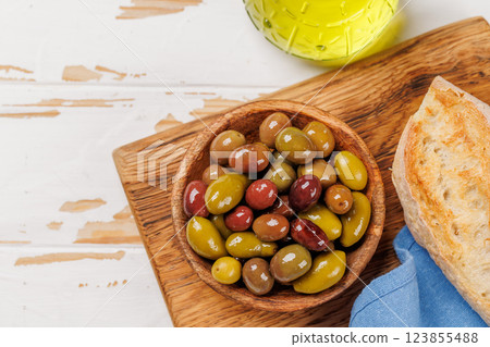 An assortment of various olives presented in a bowl, showcasing different colors, textures, and flavors 123855488