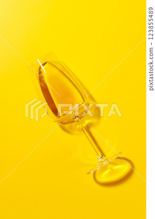 A white wine glass lying flat on a vibrant yellow background A white wine glass lying flat on a vibrant yellow background 123855489