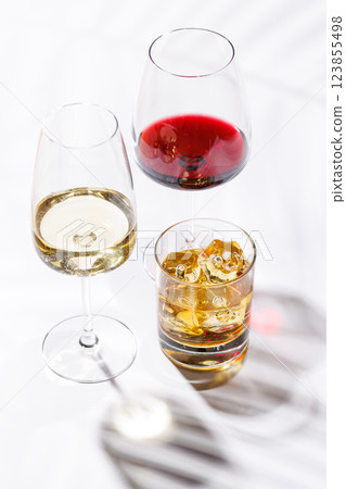 A refined composition of wine glasses filled with red and white wine, paired with a whiskey glass 123855498