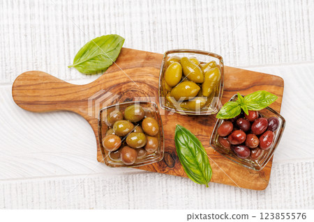 An assortment of various olives presented in a bowl, showcasing different colors, textures, and flavors An assortment of various olives presented in a bowl, showcasing different colors, textures, and flavors 123855576