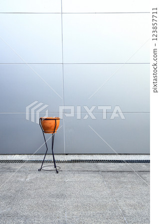 Retro style Clay pot Ashtray in front of wall made from light blue synthetic materials on modern building. Retro style Clay pot Ashtray in front of wall made from light blue synthetic materials on modern building. 123857711