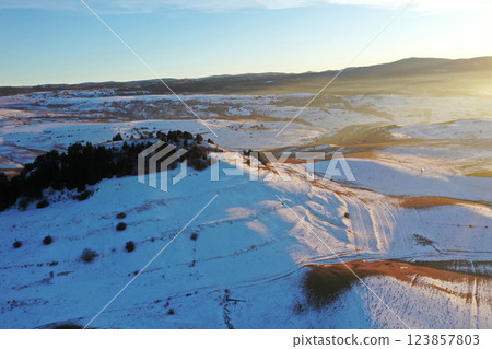Flying over snowy winter hills in sunset lights 123857803