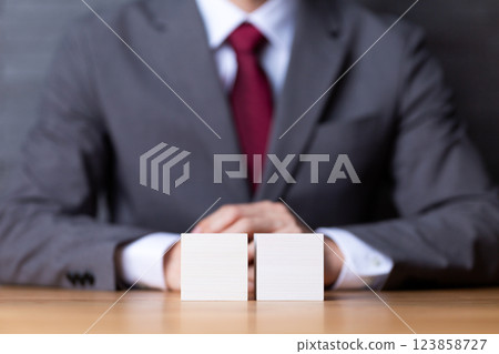 Two white wooden blocks and a middle-aged male businessman in a suit 123858727