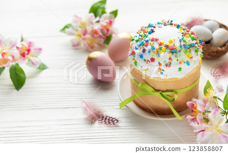 Easter cake with colorful sprinkles, pink and gold eggs and spring flowers on white wooden table Easter cake with colorful sprinkles, pink and gold eggs and spring flowers on white wooden table 123858807