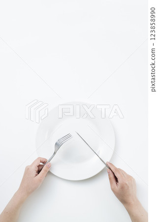 女人拿著簡單的白色盤子、叉子和刀子 123858990