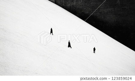 Solitary Figures Walking on Diagonal Slope in Black and White 123859024