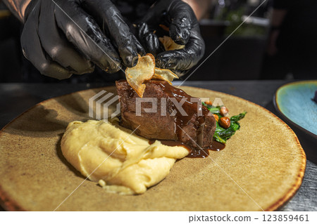 Professional chef preparing a delicious plated dish Professional chef preparing a delicious plated dish 123859461