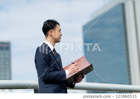 戶外有活頁夾的商人 123860513