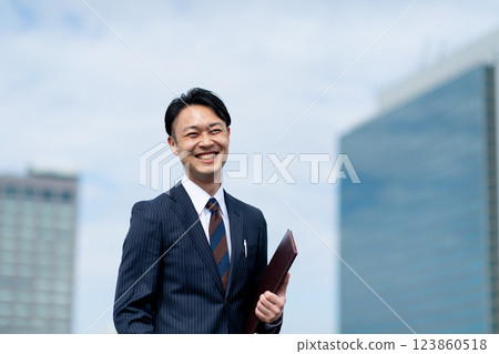 Businessman with binder outdoors 123860518
