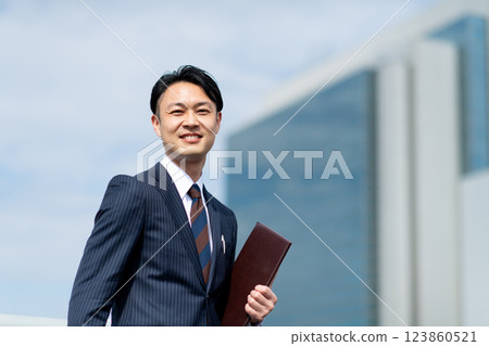 Businessman with binder outdoors 123860521