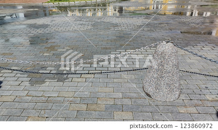 Close-up of the sidewalk fence in the form of granite posts with iron chains Close-up of the sidewalk fence in the form of granite posts with iron chains 123860972