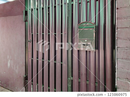 Modern mailbox on a new metal gate made of siding and profiles Modern mailbox on a new metal gate made of siding and profiles 123860975