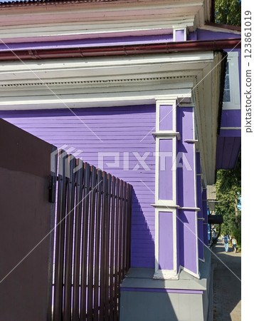 Corner of residential purple house with concrete foundation and metal siding fence Corner of residential purple house with concrete foundation and metal siding fence 123861019