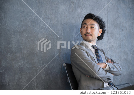 A businessman in a suit sitting in a chair and looking up, turning around. Image of success and goals A businessman in a suit sitting in a chair and looking up, turning around. Image of success and goals 123861053