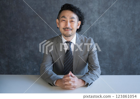 Smiling businessman talking to the camera Smiling businessman talking to the camera 123861054