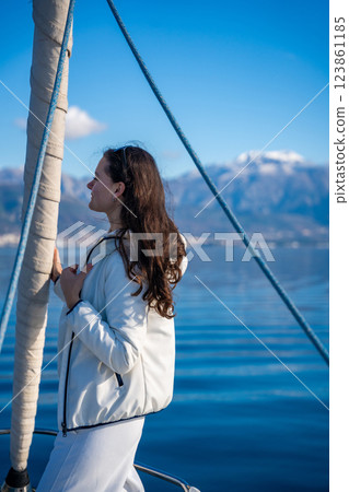 Portrait of young woman on bow of the yacht during sailing in the morning in winter time in Adriatic sea, yacht life and yachting concept 123861185