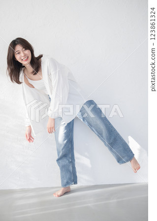 穿著牛仔布和白襯衫的時尚可愛女人 穿著牛仔布和白襯衫的時尚可愛女人 123861324