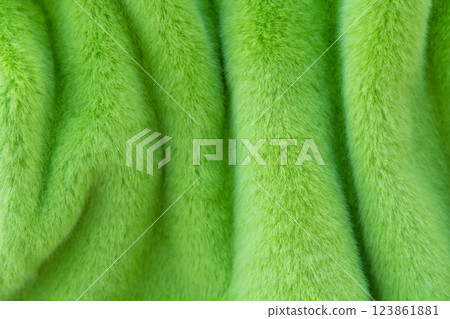 Close-up of soft green faux fur fabric with vertical folds. Close-up of soft green faux fur fabric with vertical folds. 123861881
