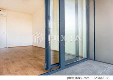 Tilt and slide glass door system for modern balcony access in residential apartment interior. Tilt and slide glass door system for modern balcony access in residential apartment interior. 123861970