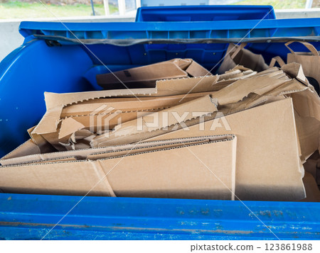 Recycling bin with discarded cardboard waste for sustainable waste management. Recycling bin with discarded cardboard waste for sustainable waste management. 123861988