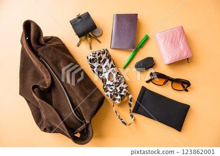 Flat lay of travel essentials with suede bag on pastel background 123862001