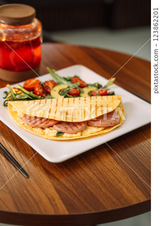 Toasted Tortilla with Sausage and salad on white plate 123862201