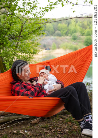 Mother and Baby Relaxing in Hammock Outdoors 123862203