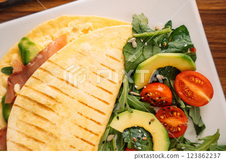 Tortilla with salmon with salad in a square white plate Tortilla with salmon with salad in a square white plate 123862237
