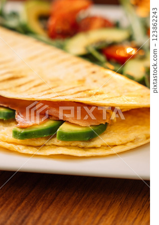 Tortilla with salmon with salad in a white plate Tortilla with salmon with salad in a white plate 123862243