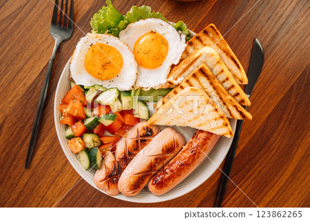 A hearty breakfast of fried eggs, sausages and toast A hearty breakfast of fried eggs, sausages and toast 123862265