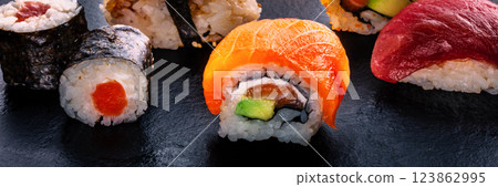 Sushi rolls on a black background panorama. Uramaki with salmon Sushi rolls on a black background panorama. Uramaki with salmon 123862995