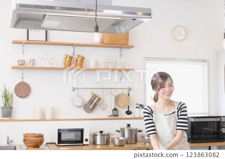 A woman in an apron cooking in the kitchen 123863082