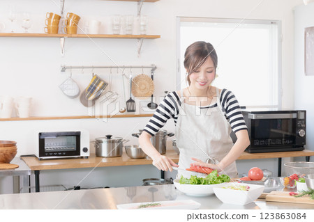 A woman in an apron cooking in the kitchen 123863084