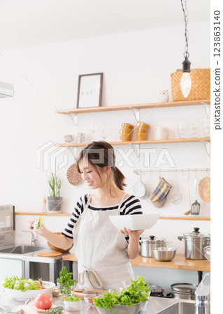 一個圍裙，在廚房裡做飯的女人 123863140