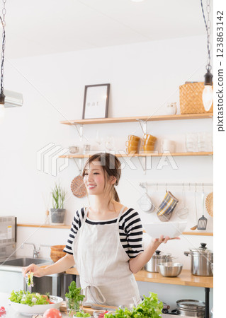 一個圍裙，在廚房裡做飯的女人 123863142